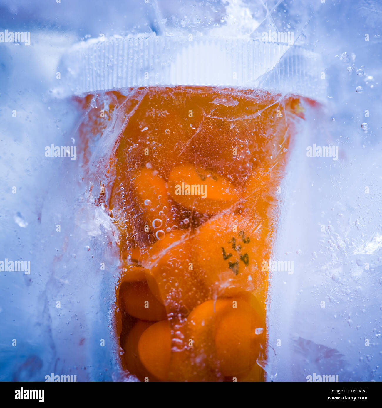 bottle of prescription drug pills frozen in ice Stock Photo