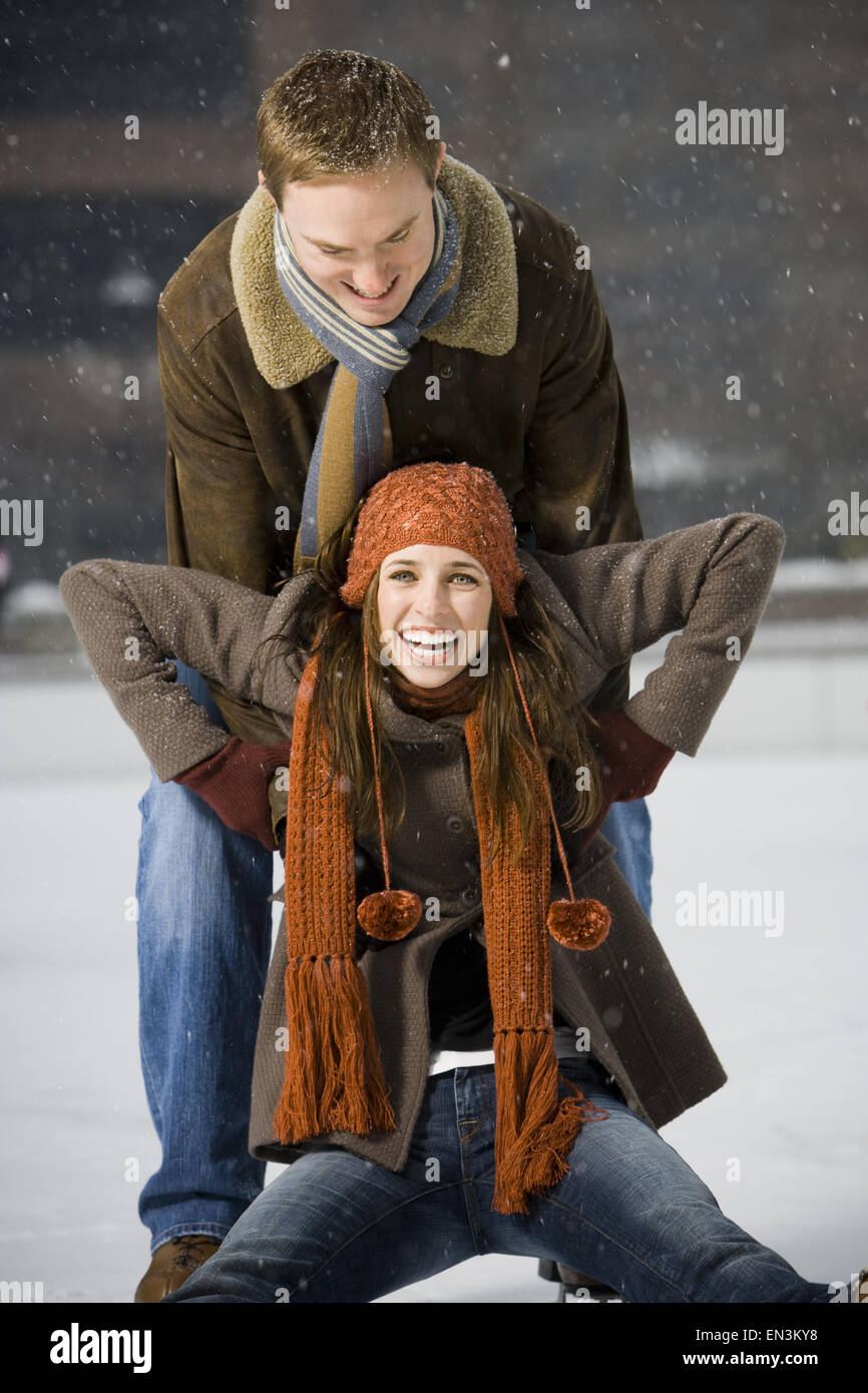 Couple falling while ice skating Stock Photo