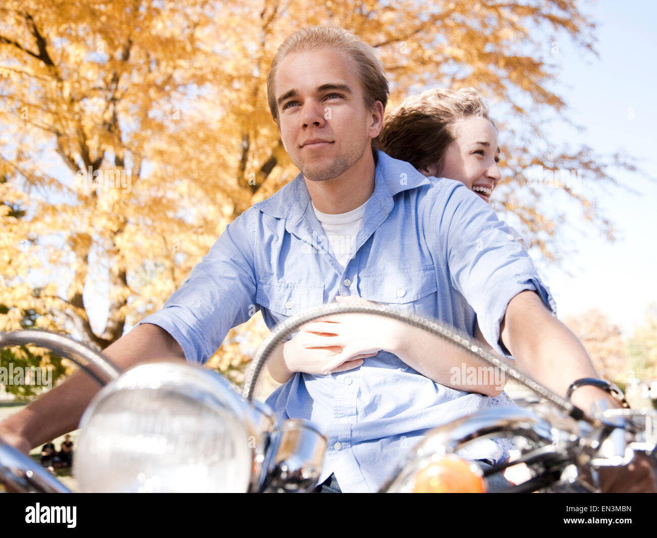 Young couple riding on motorcycle in Autumn forest Stock Photo