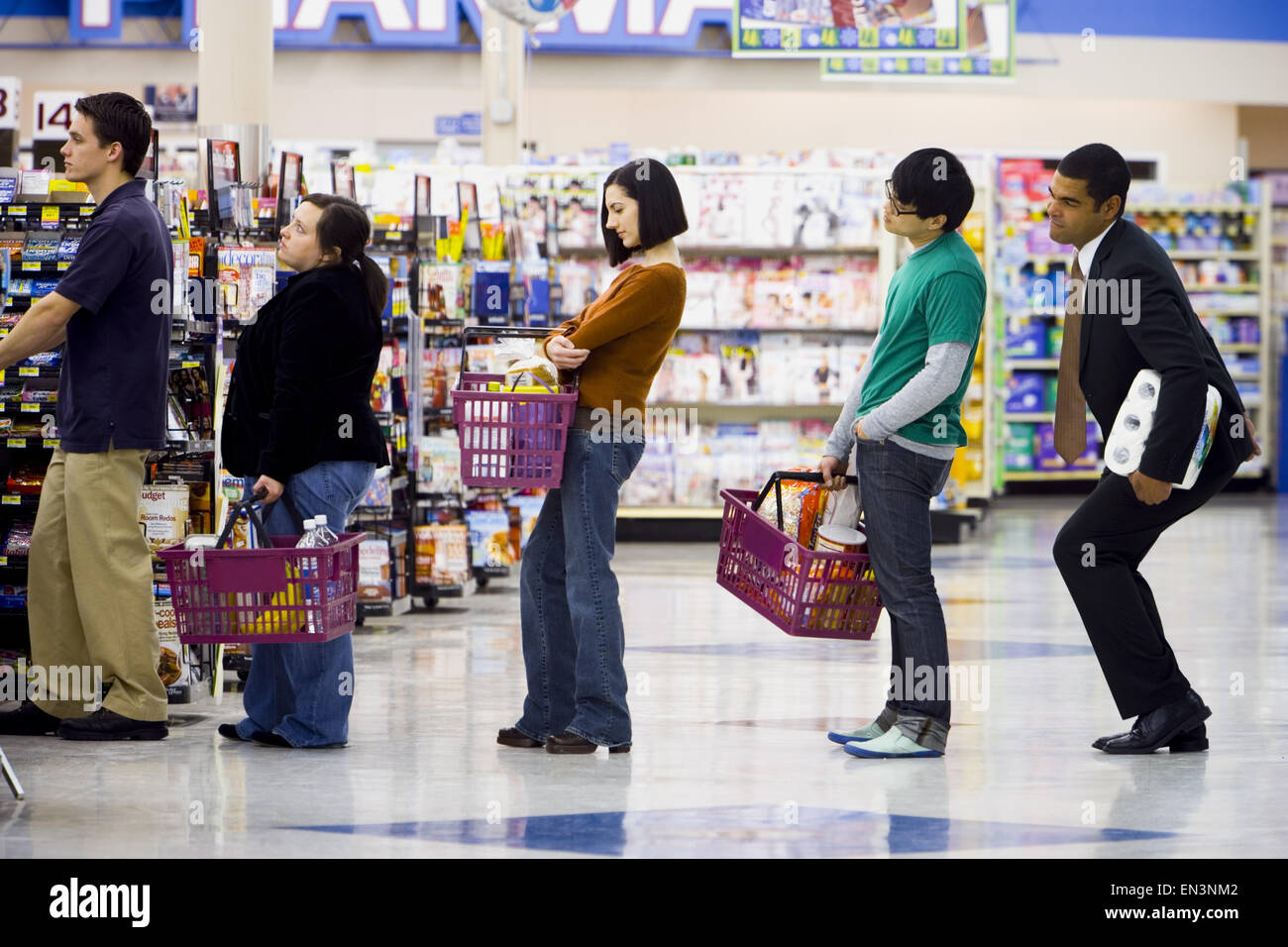 People waiting in line with shopping baskets at grocery store Stock Photo