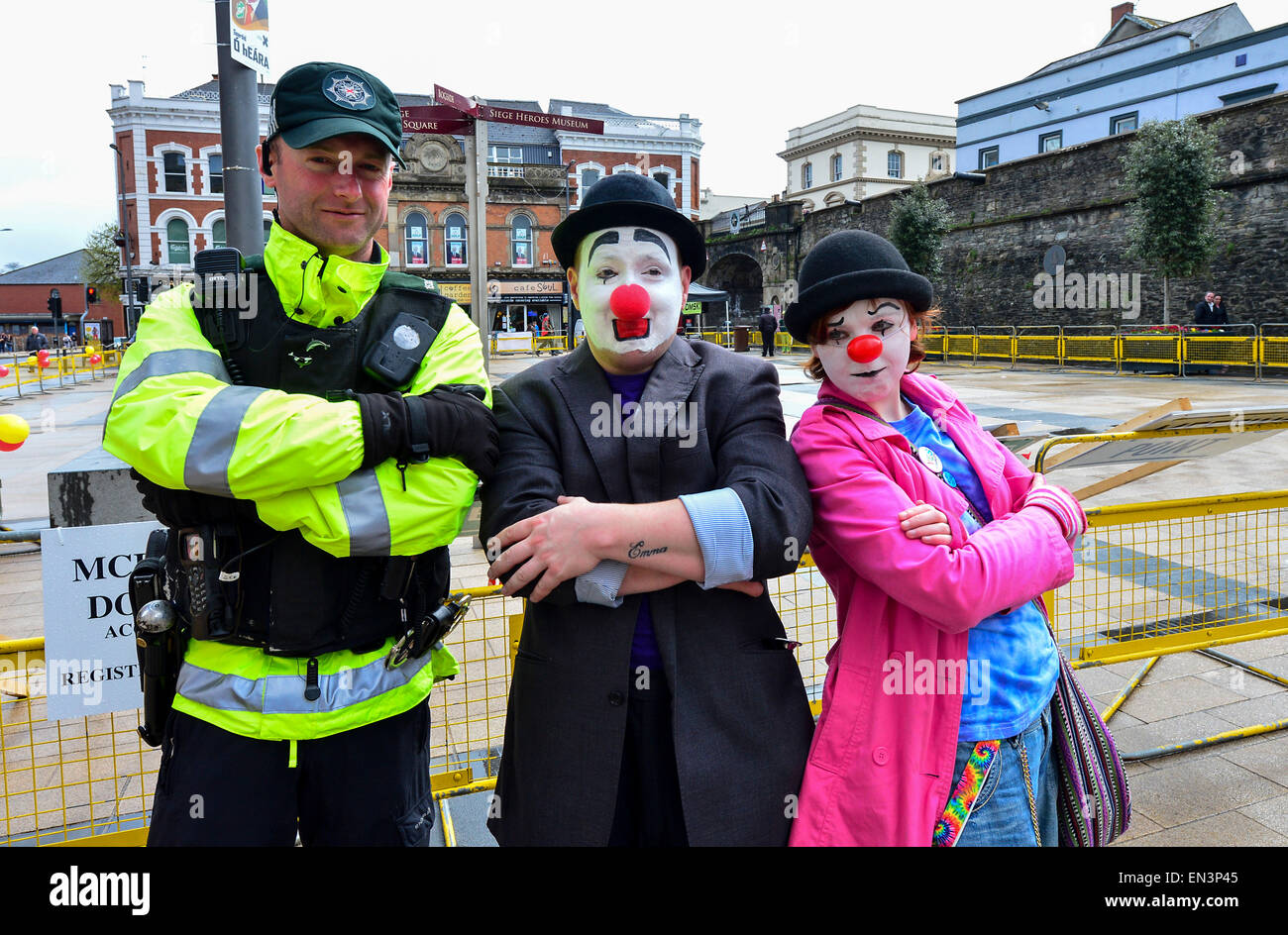 PSNI constable posing with two clowns, at a charity event in the Guildhall Square, Derry, Londonderry. Stock Photo