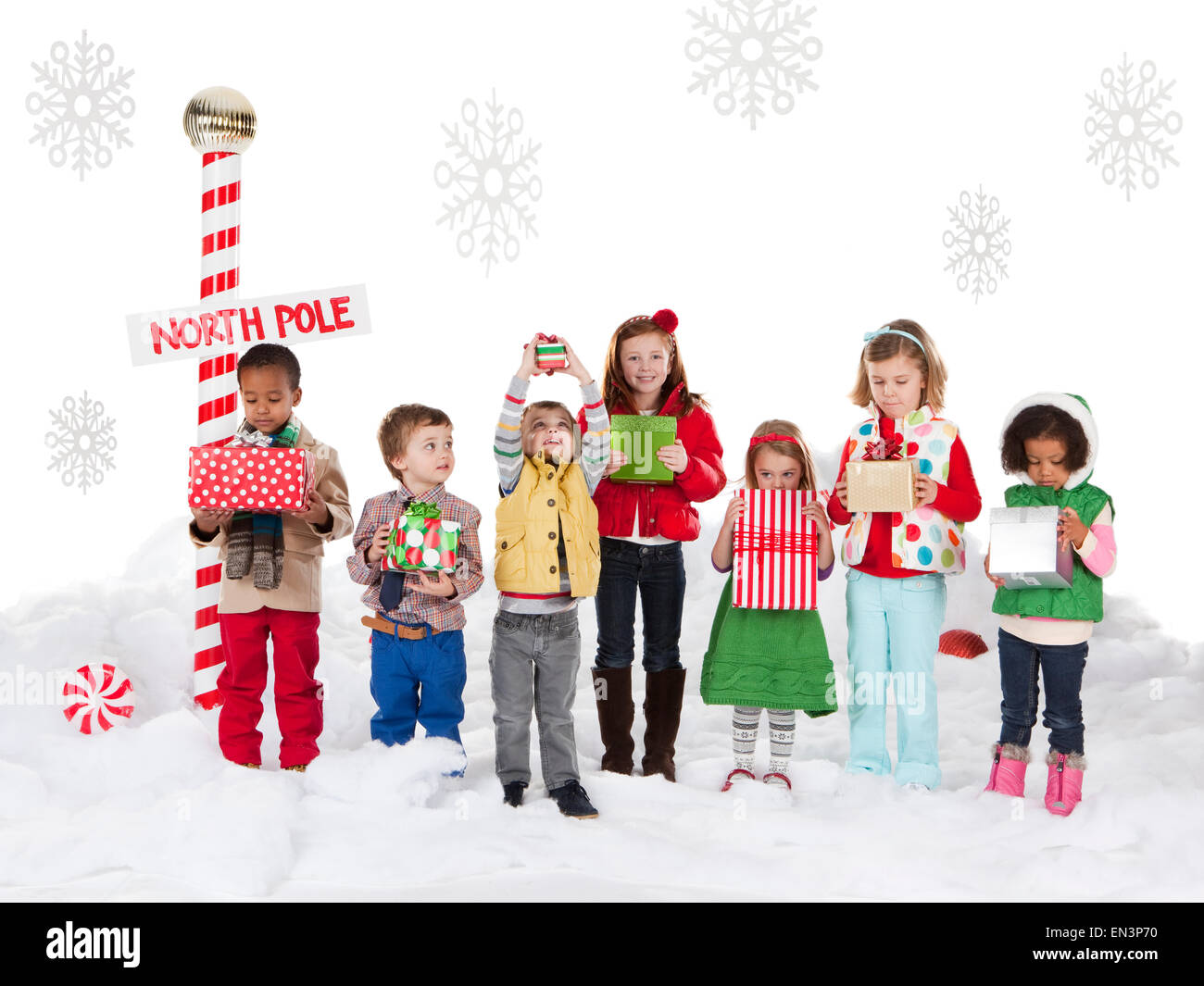 Group of kids (18-23months, 2-3, 4-5, 6-7) standing next to North Pole sign Stock Photo