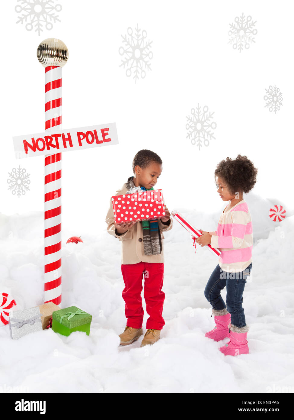 Boy (4-5) and girl (4-5) standing next to North Pole sign Stock Photo