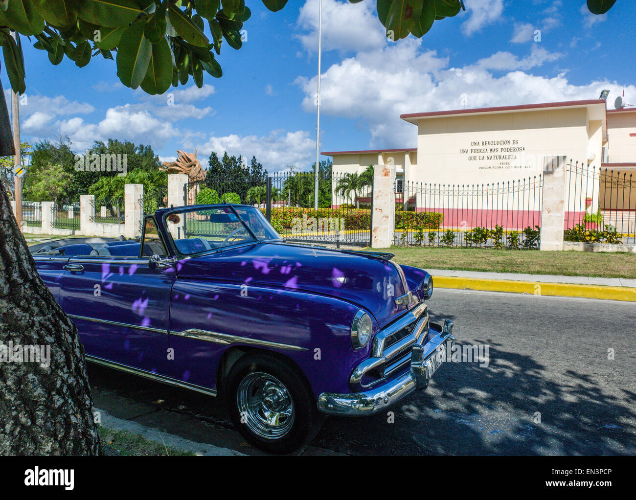 Vintage purple car parked in front of  'Una Revolucion Es Una Fuerza Mas Poderosa Que La Naturaleza' Civil Defense Building, Havana. Stock Photo