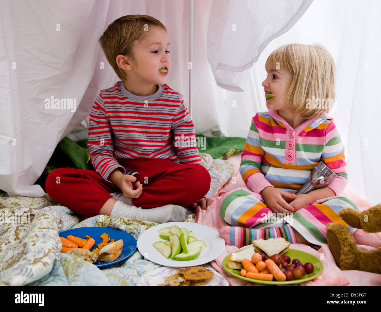 brother and sister in a makeshift fort eating lunch Stock Photo