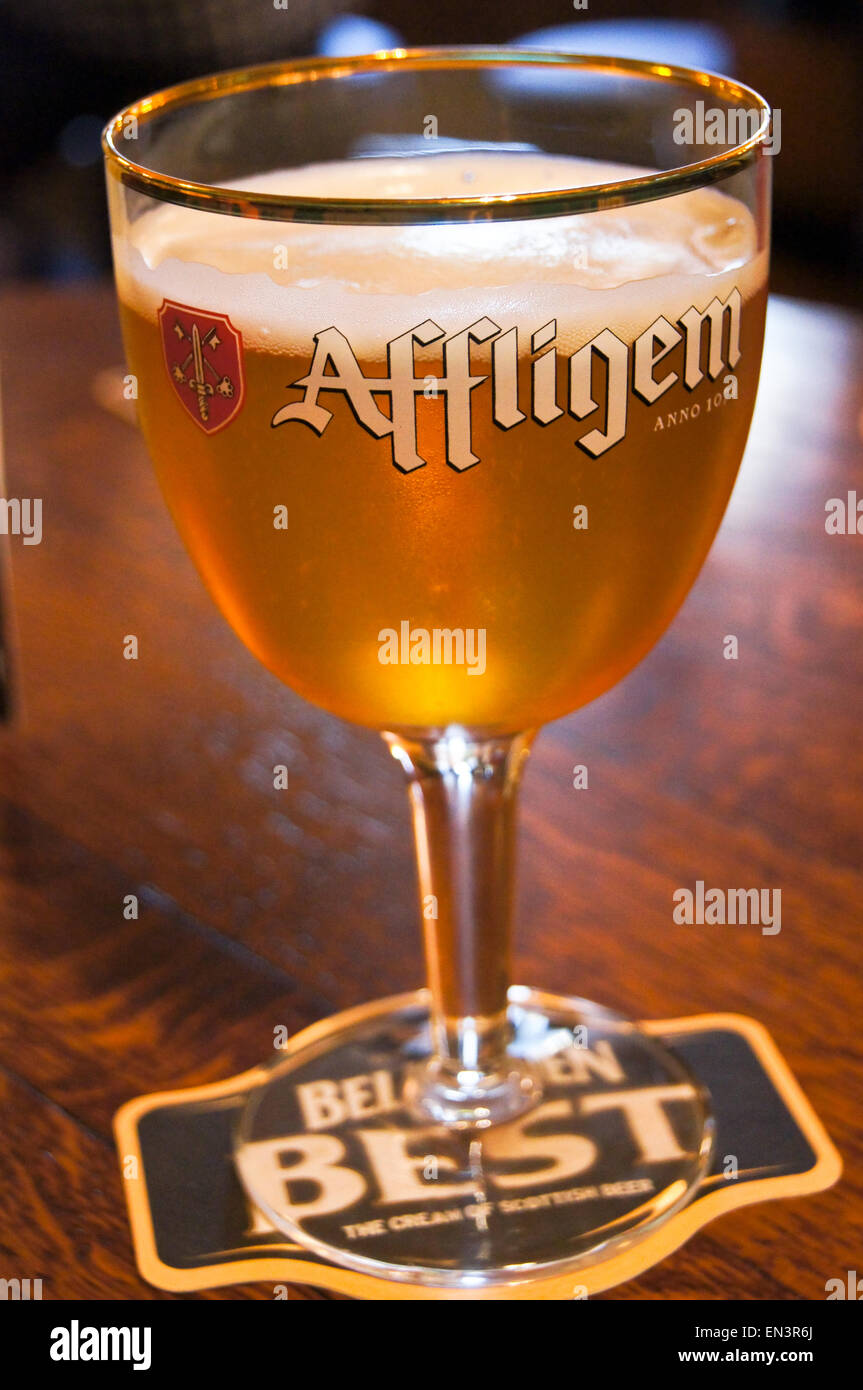 A printed glass of Affligem Belgian abbey beer in a branded chalice on