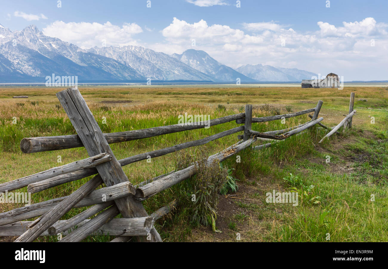 Early Mormon homestead and collapsed fence against the Grand Teton Mountains and in the middle of the prairie at Mormon Row. Stock Photo