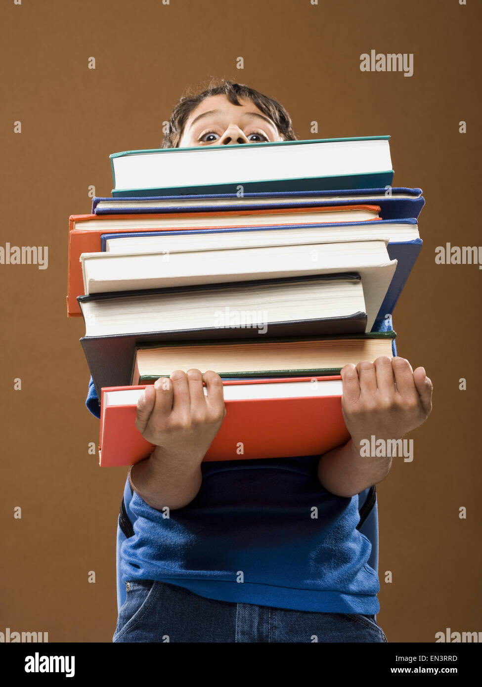 Boy holding pile of textbooks Stock Photo - Alamy