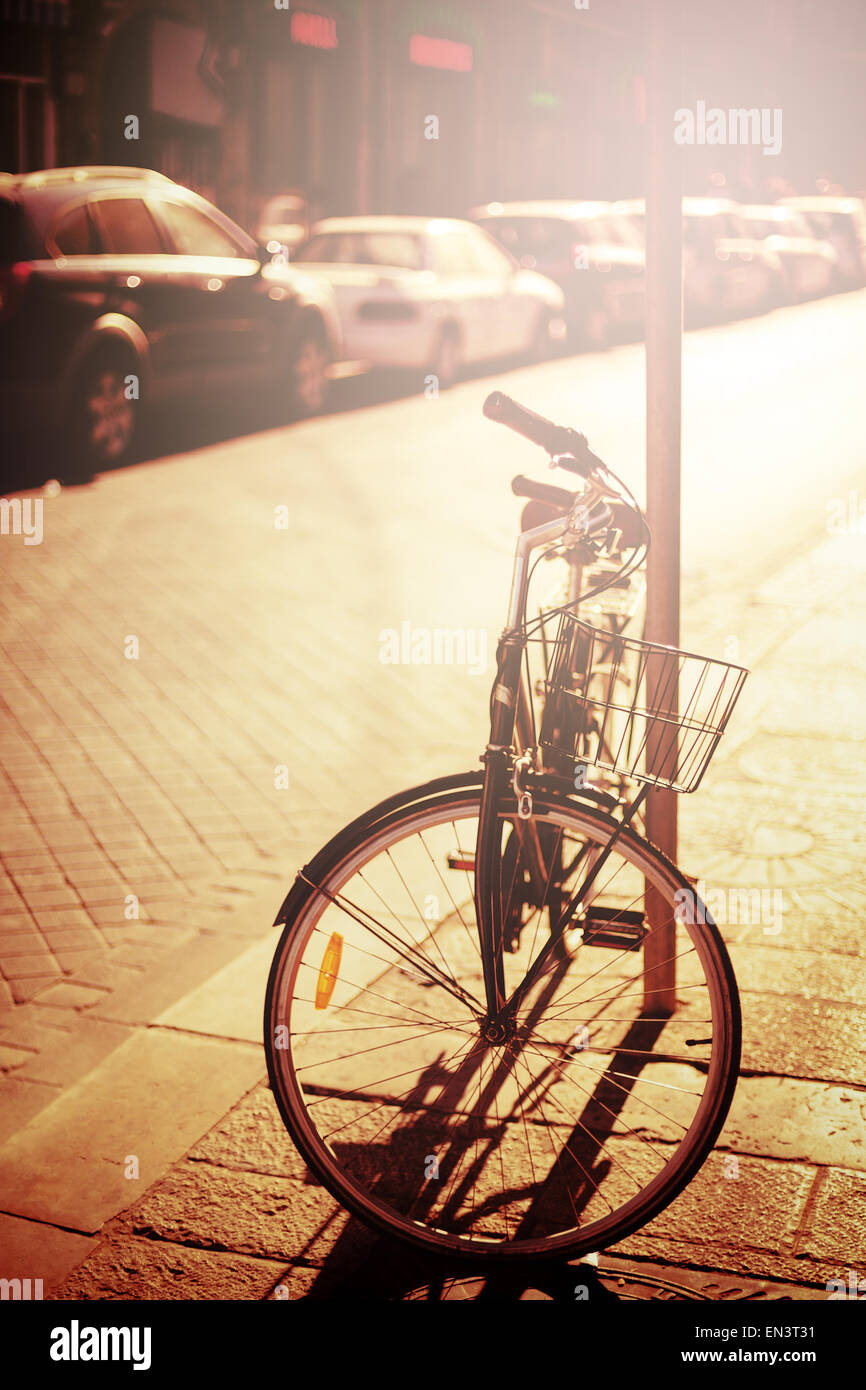 Bicycle resting at the street. Instagram effect, image toned in vintage colors. Selective focus. Stock Photo