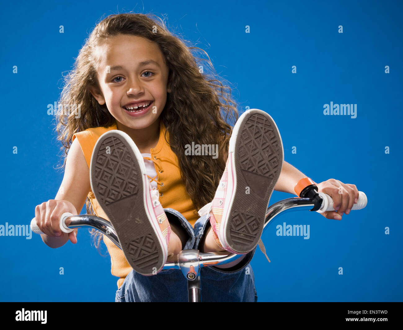 Girl riding bicycle with feet on handlebars Stock Photo Alamy