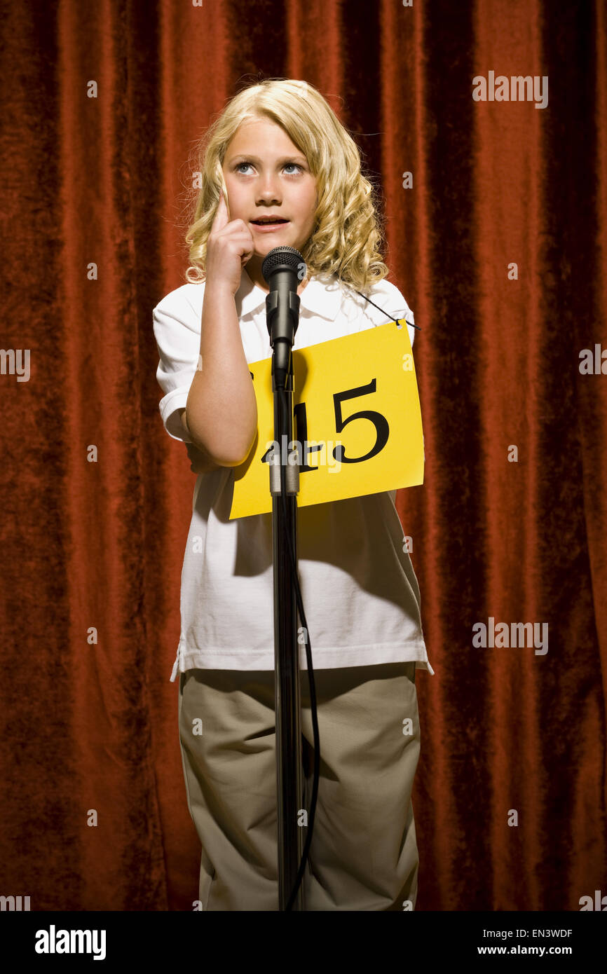 Girl contestant standing at microphone thinking Stock Photo