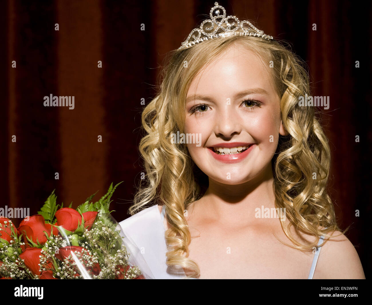 Beauty pageant winner smiling and holding roses Stock Photo