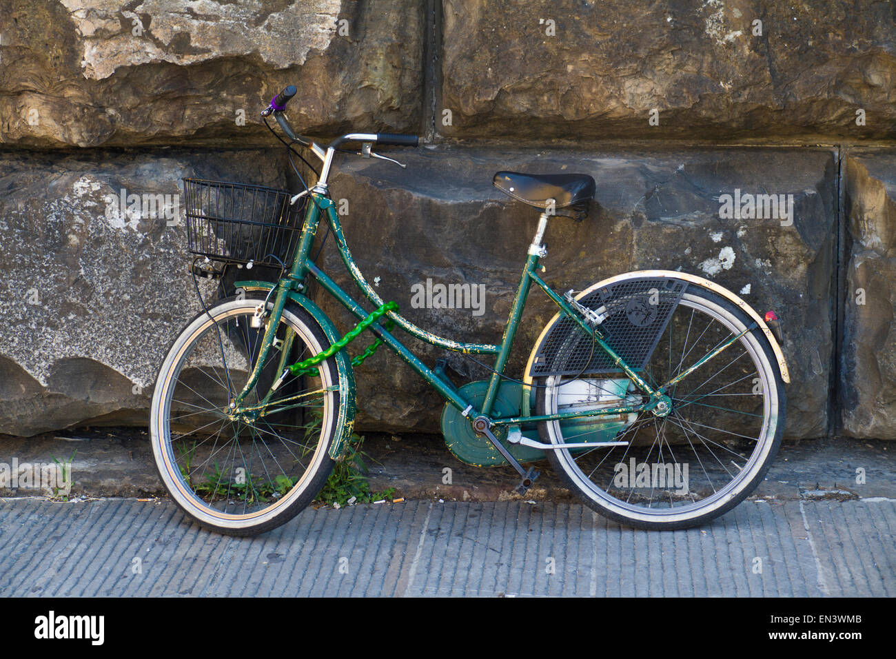 Italy, Florence, Old green bike against stone wall Stock Photo