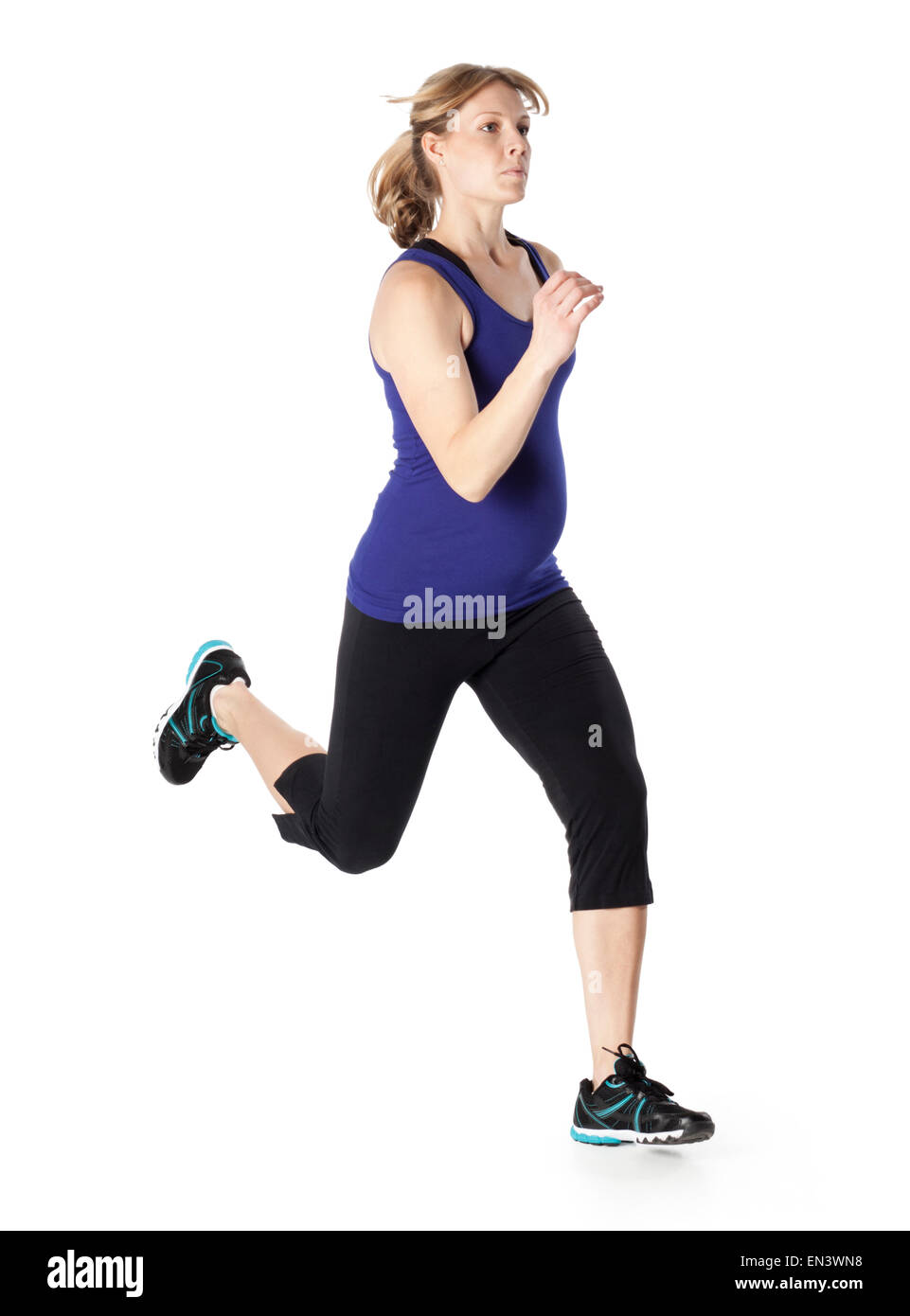Young pregnant woman in sports clothing running, studio shot Stock