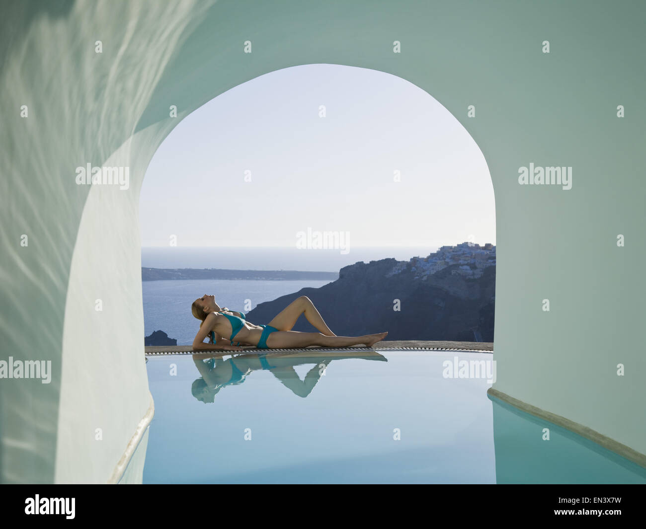 Woman reclining by pool outdoors Stock Photo