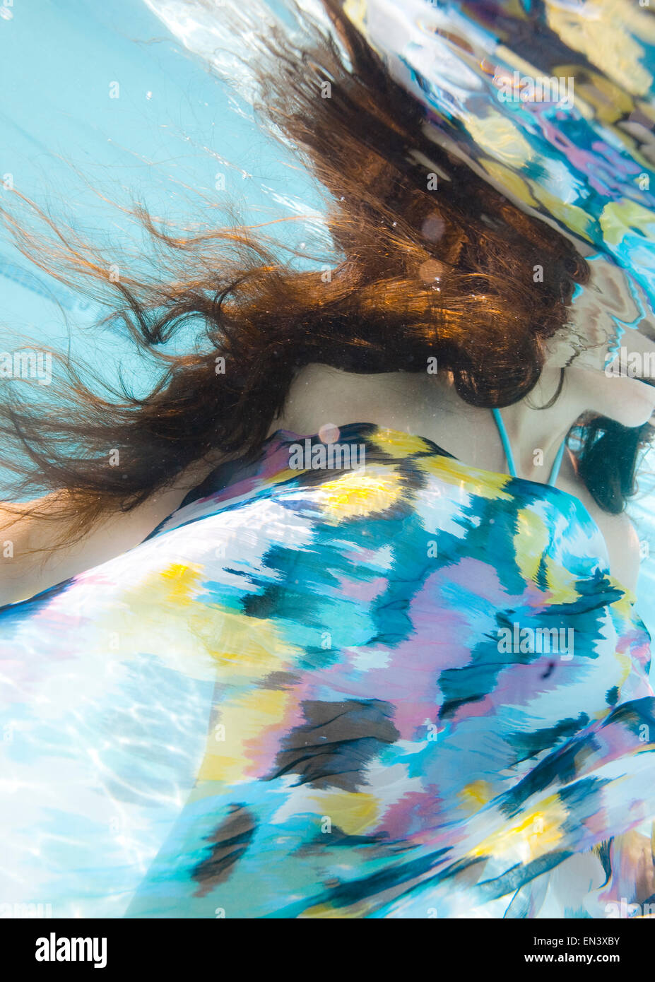 USA, Utah, Orem, Young woman under water wrapped in colorful textile ...