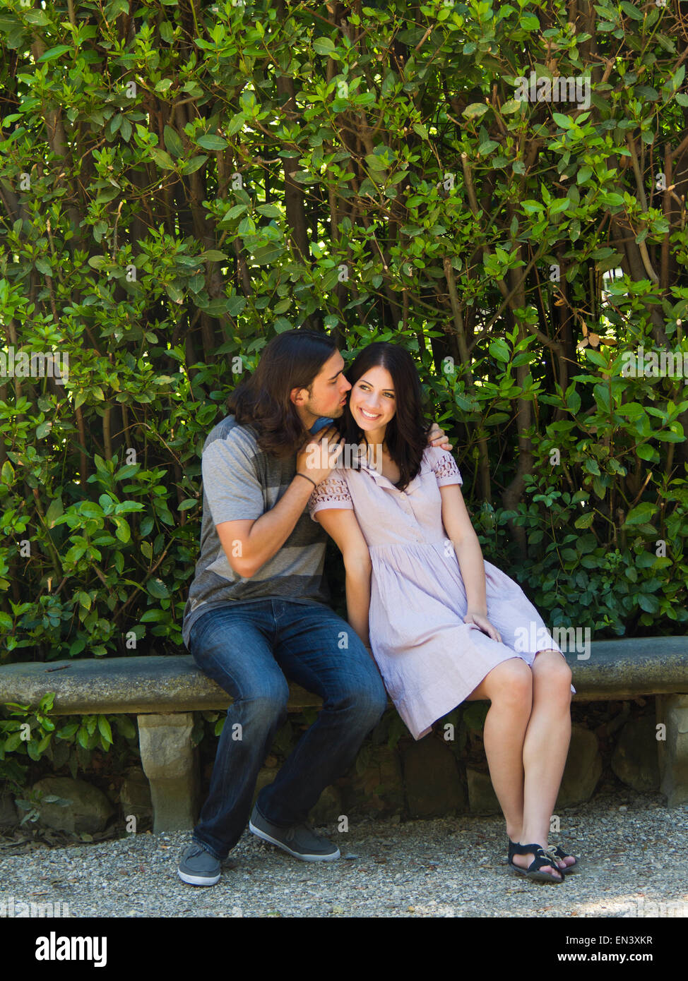Italy, Florence, Affectionate young couple sitting on bench Stock Photo