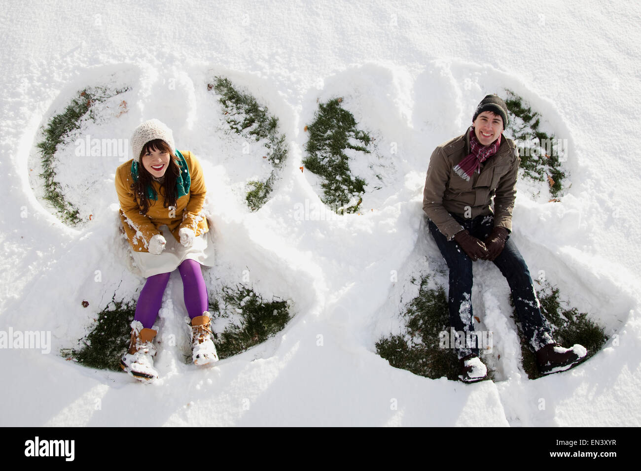 young couple making snow angels Stock Photo