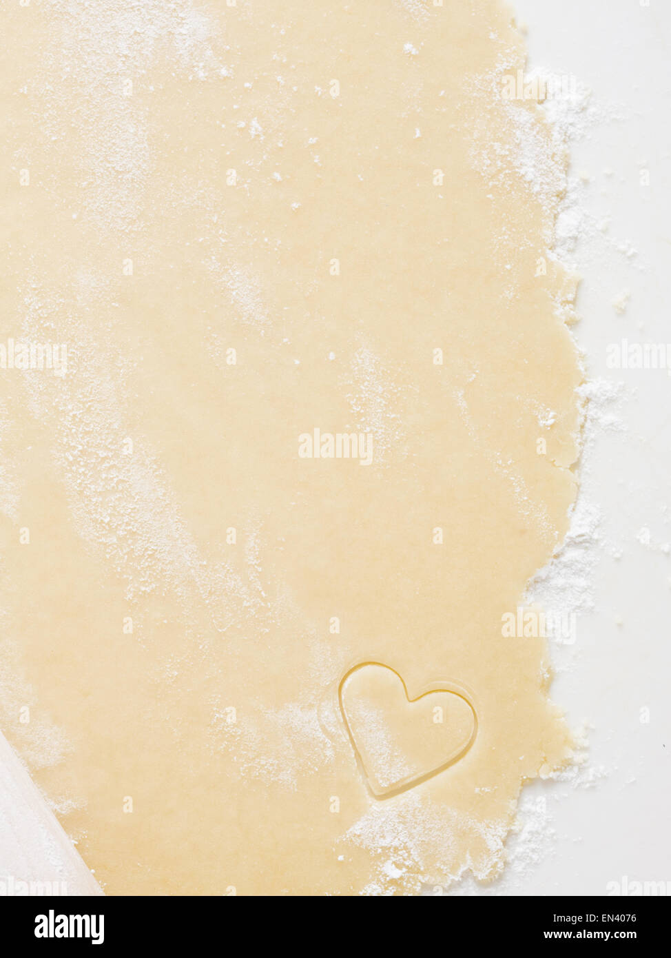 Detailed view of dough with hearts and rolling pin Stock Photo