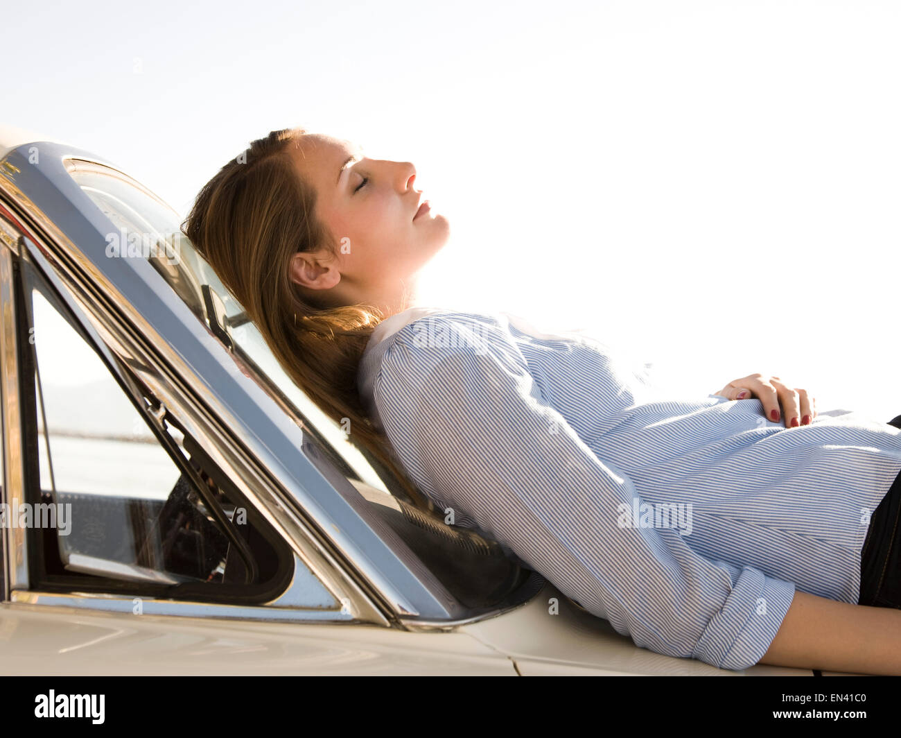 woman asleep on the hood of her car Stock Photo Alamy