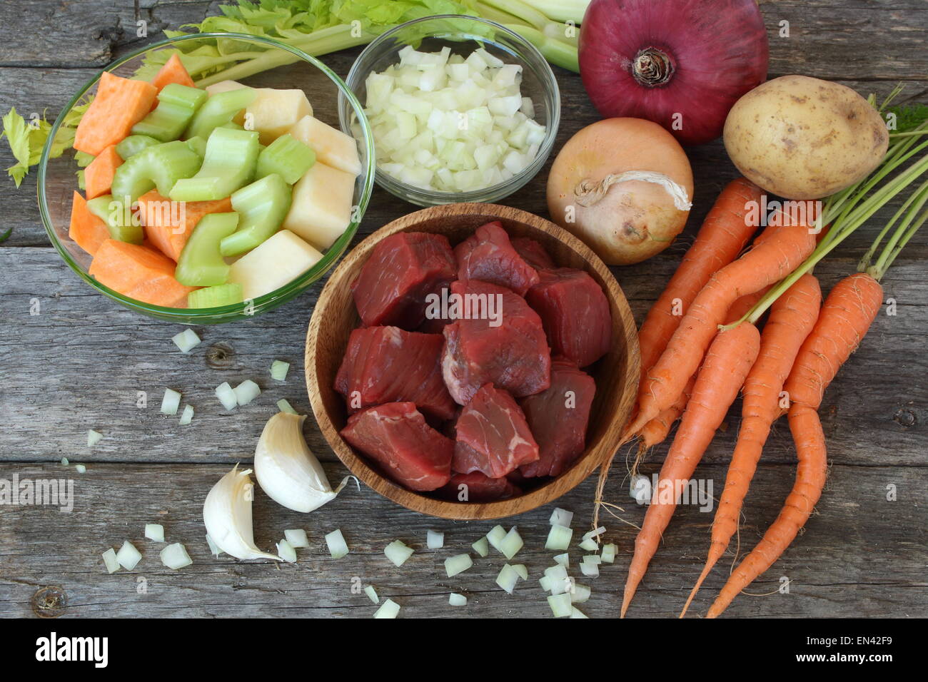 Raw ingredients to prepare a stew beef, carrots, rutabaga, garlic
