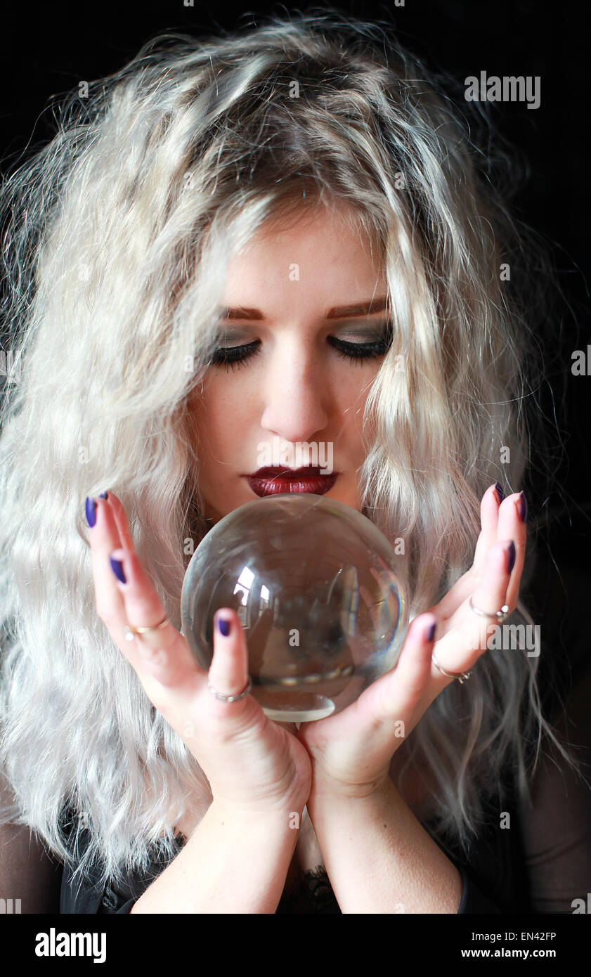 Beautiful young woman holding a crystal ball Stock Photo - Alamy