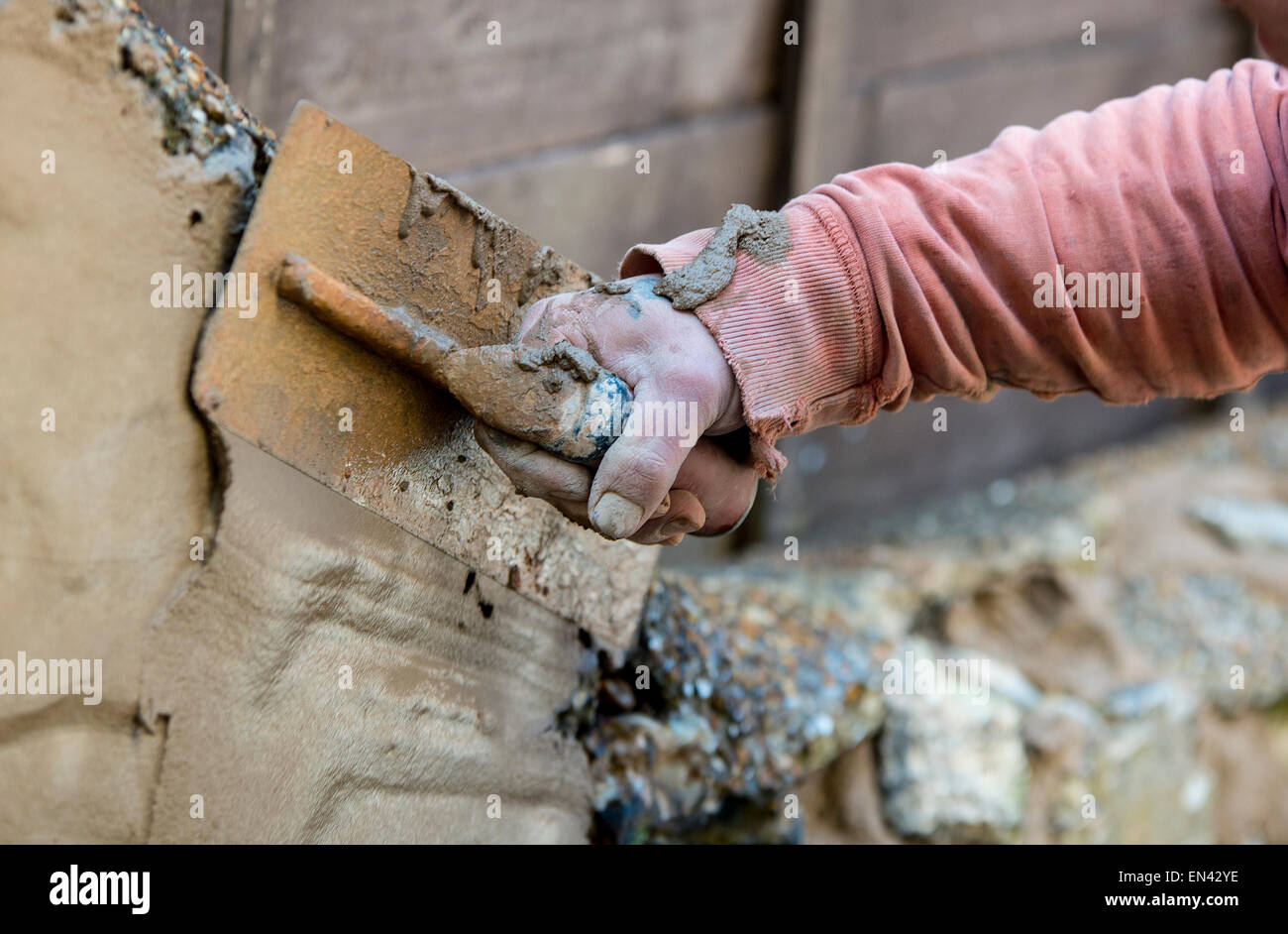 Close up picture of a man rendering an outside wall on a property Stock Photo