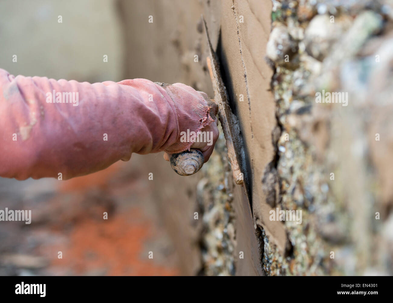 Close up picture of a man rendering an outside wall on a property Stock Photo