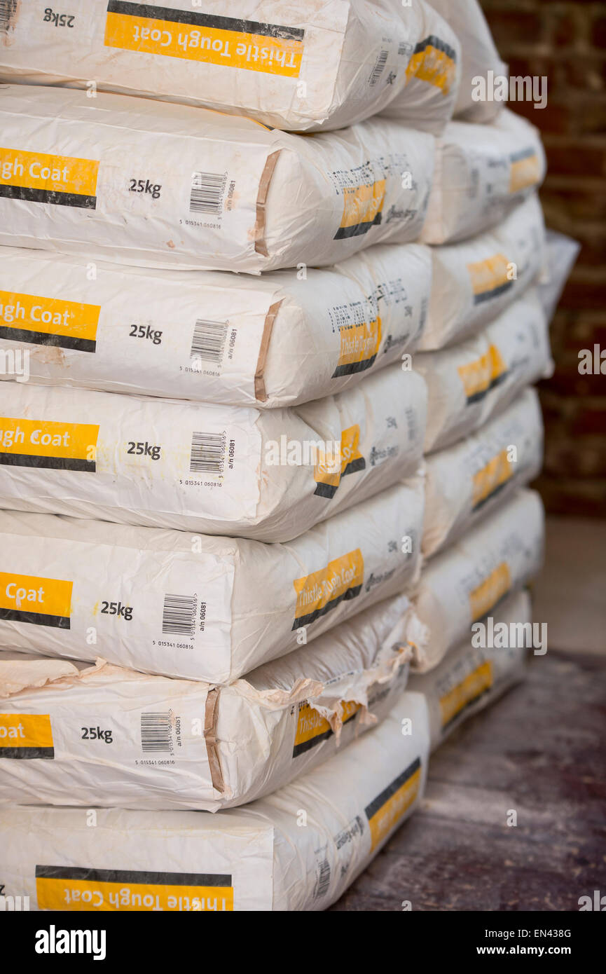 A stack of 25kg thistle tough coast plaster bags stacked on a site. Stock Photo