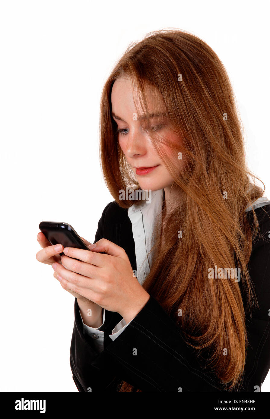 A young business woman texting on her cell phone, with long brunette ...