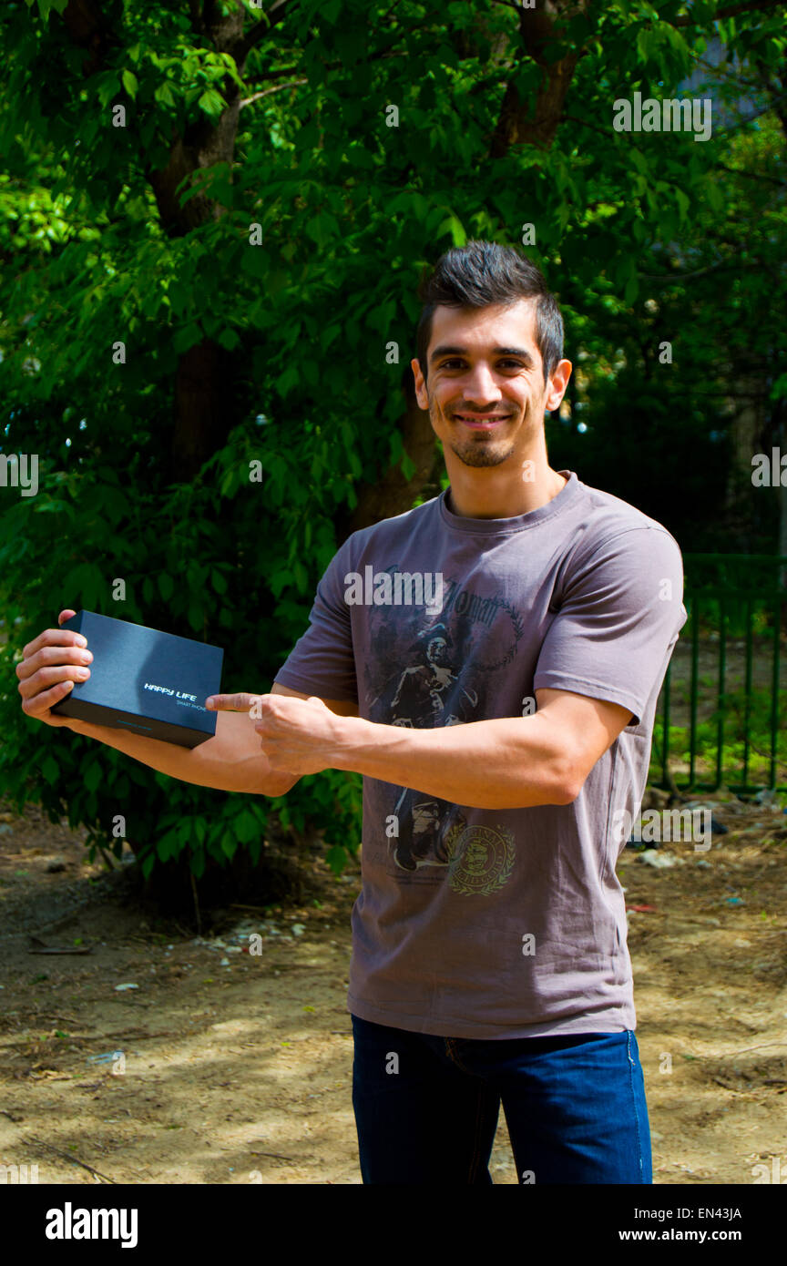 Young men with great body casual wear winning a smartphone in box and it's very happy Stock Photo