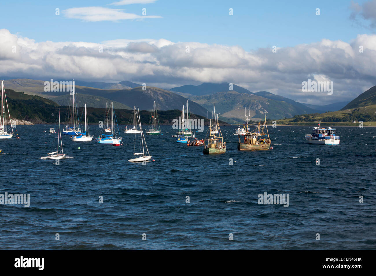 View of Fishing boats moored in Loch Broom at Ullapool with cloud passing across Beinn Dearg  Wester Ross Scotland Stock Photo