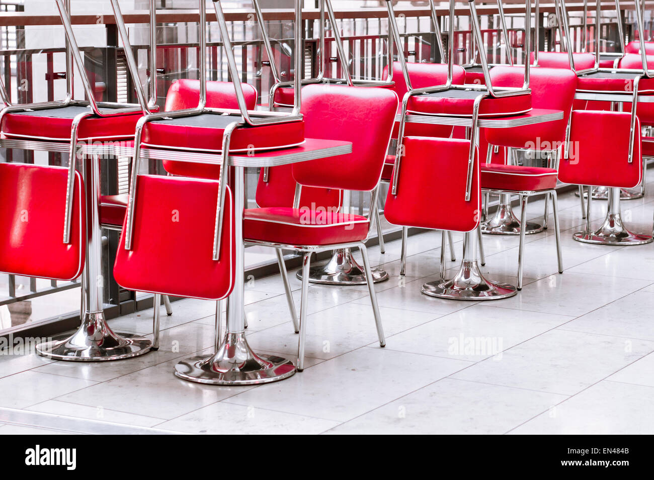Stacked red leather chairs in a closed restaurant in the UK Stock Photo