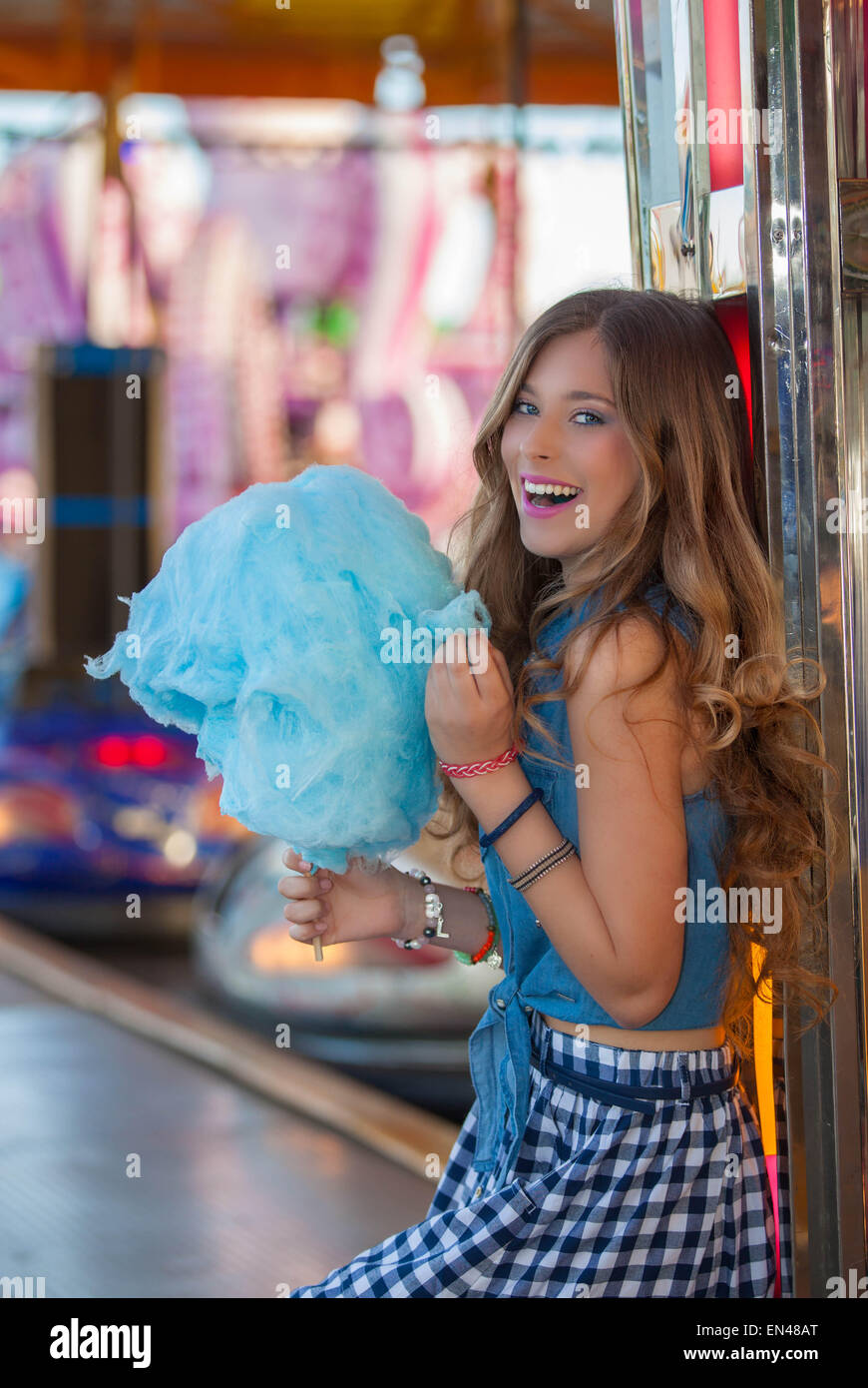 happy teen at fair eating candy floss or cotton. Stock Photo