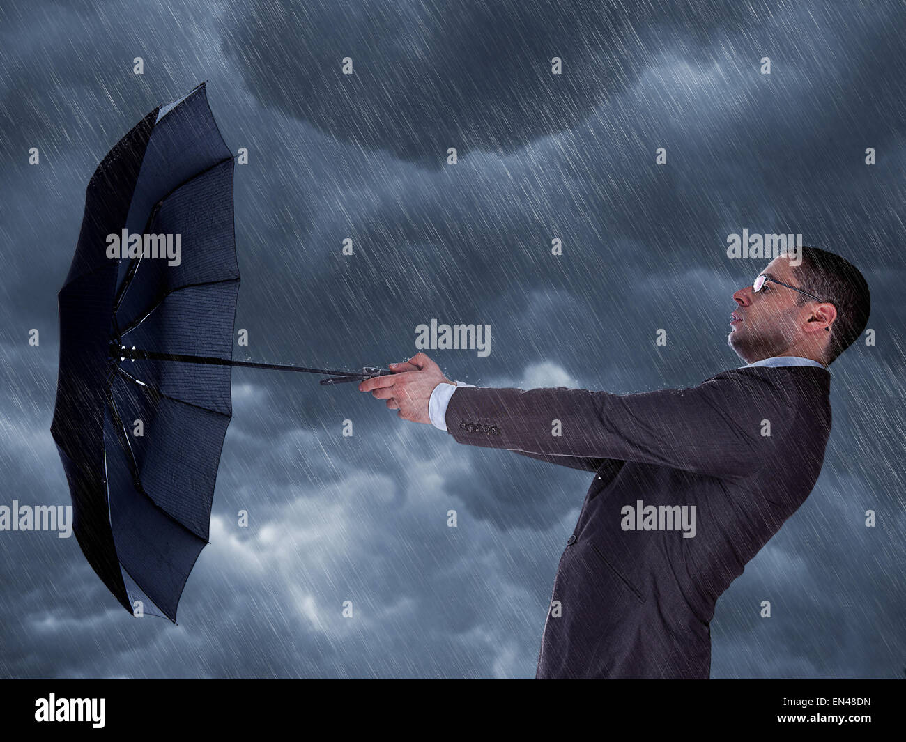 A businessman with an umbrella protecting himself from a driving ...