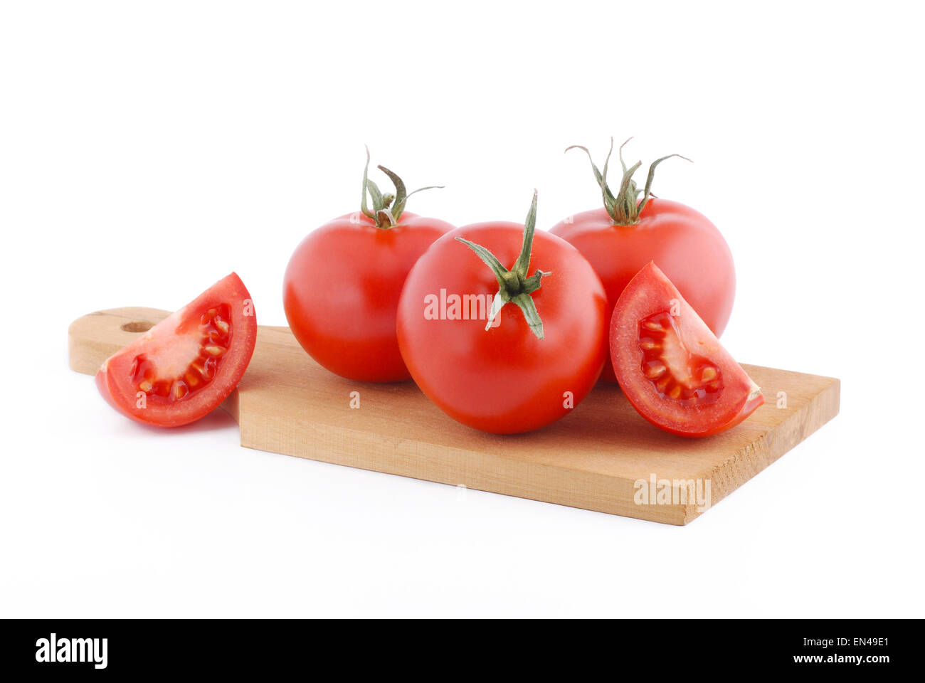 pile of ripe tomatoes on cutting board on white background Stock Photo ...