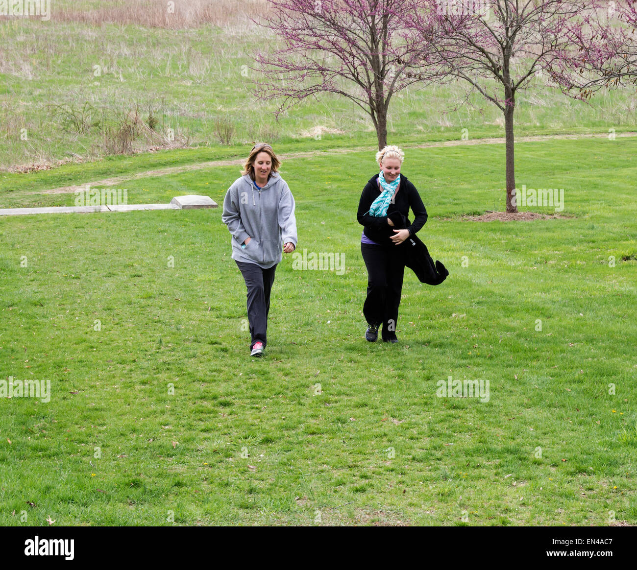 Two women walking and talking in the park. Stock Photo