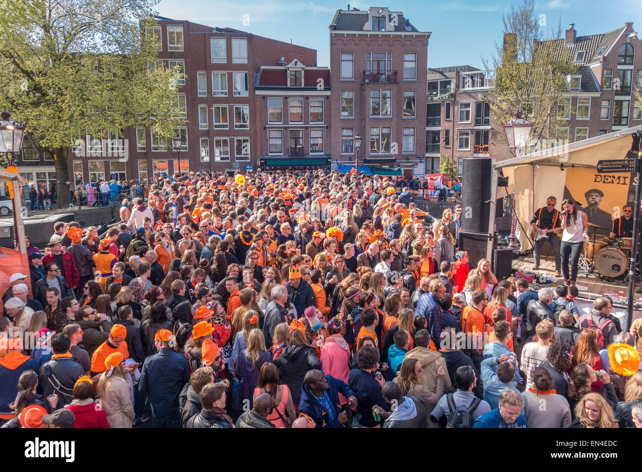 Crowds of people blocking a bridge when a band is performing on Koningsdag, Kings Day in Amsterdam on the Prinsengracht Canal Stock Photo