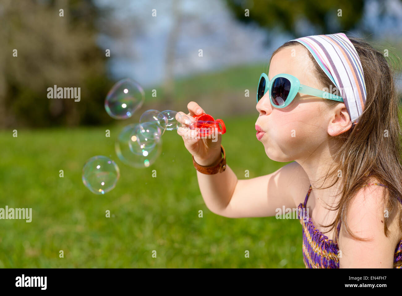 a little girl making soap bubbles in nature Stock Photo - Alamy