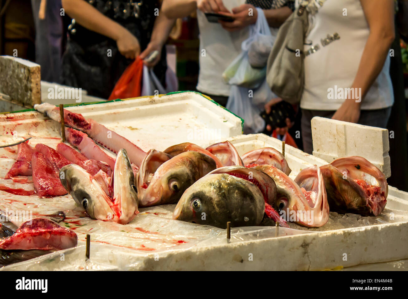 Wet Market Hong Kong China fish sale head parts eyes face teeth wet blood guts mouth bloody tourists Stock Photo