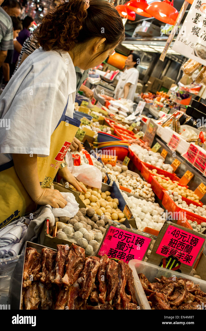 Wet Market Hong Kong China fruit vegetable meat sale stand display hanging active selling tourists buy food Asian worker signs Stock Photo