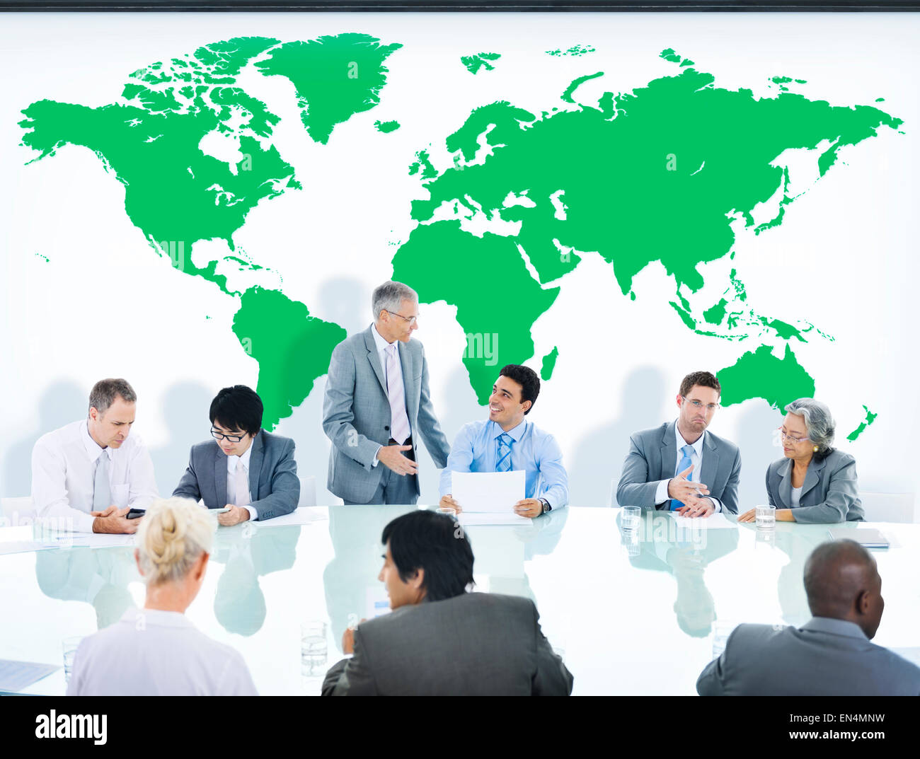 Business People Having a Discussion and World Map Stock Photo