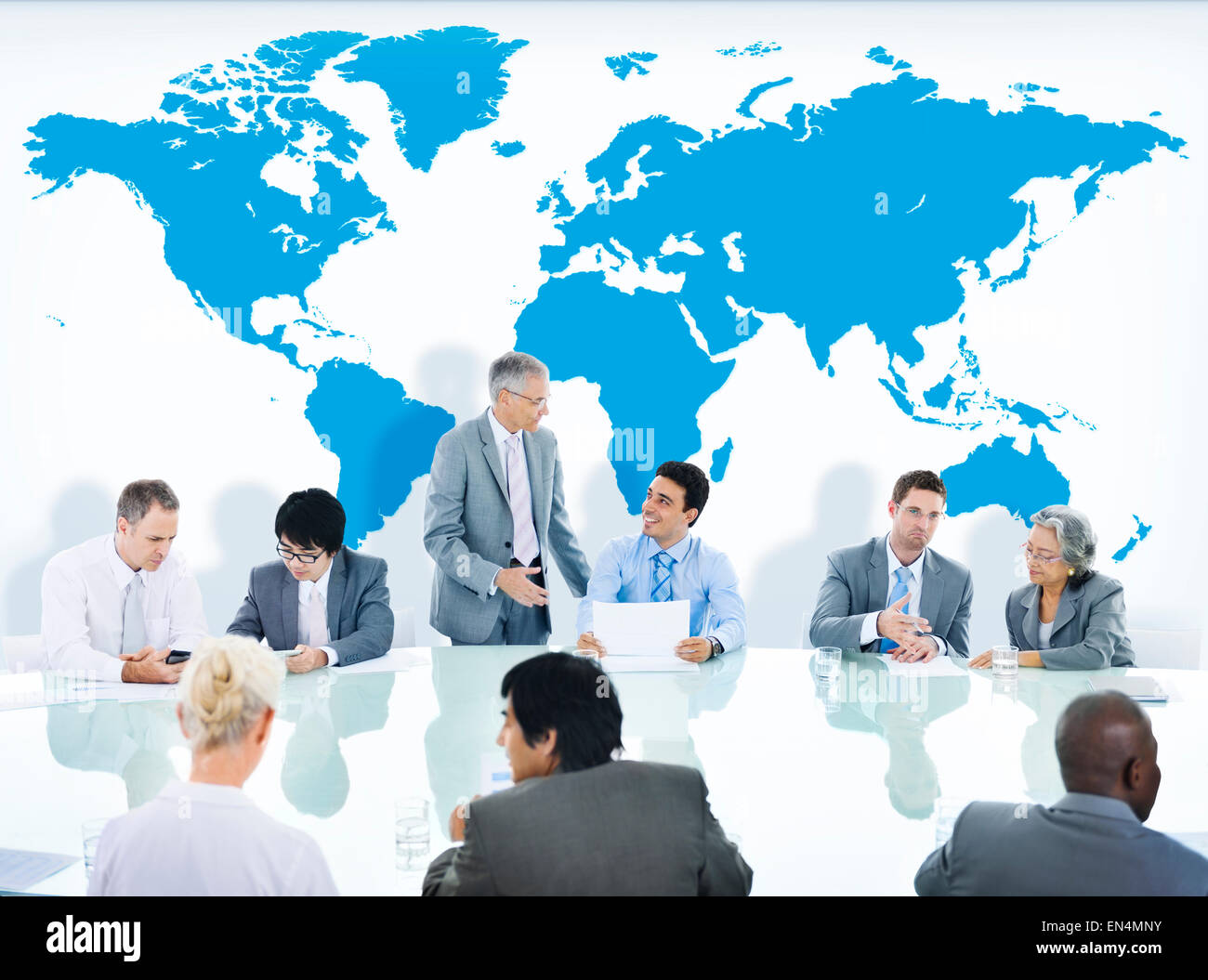 Business People Having a Discussion and World Map Stock Photo