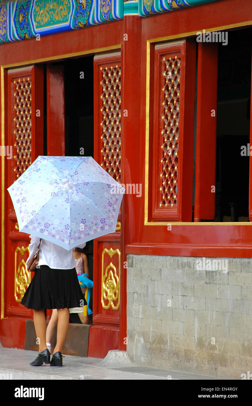 Chinese Girl outside Red Door holding umbrella Stock Photo