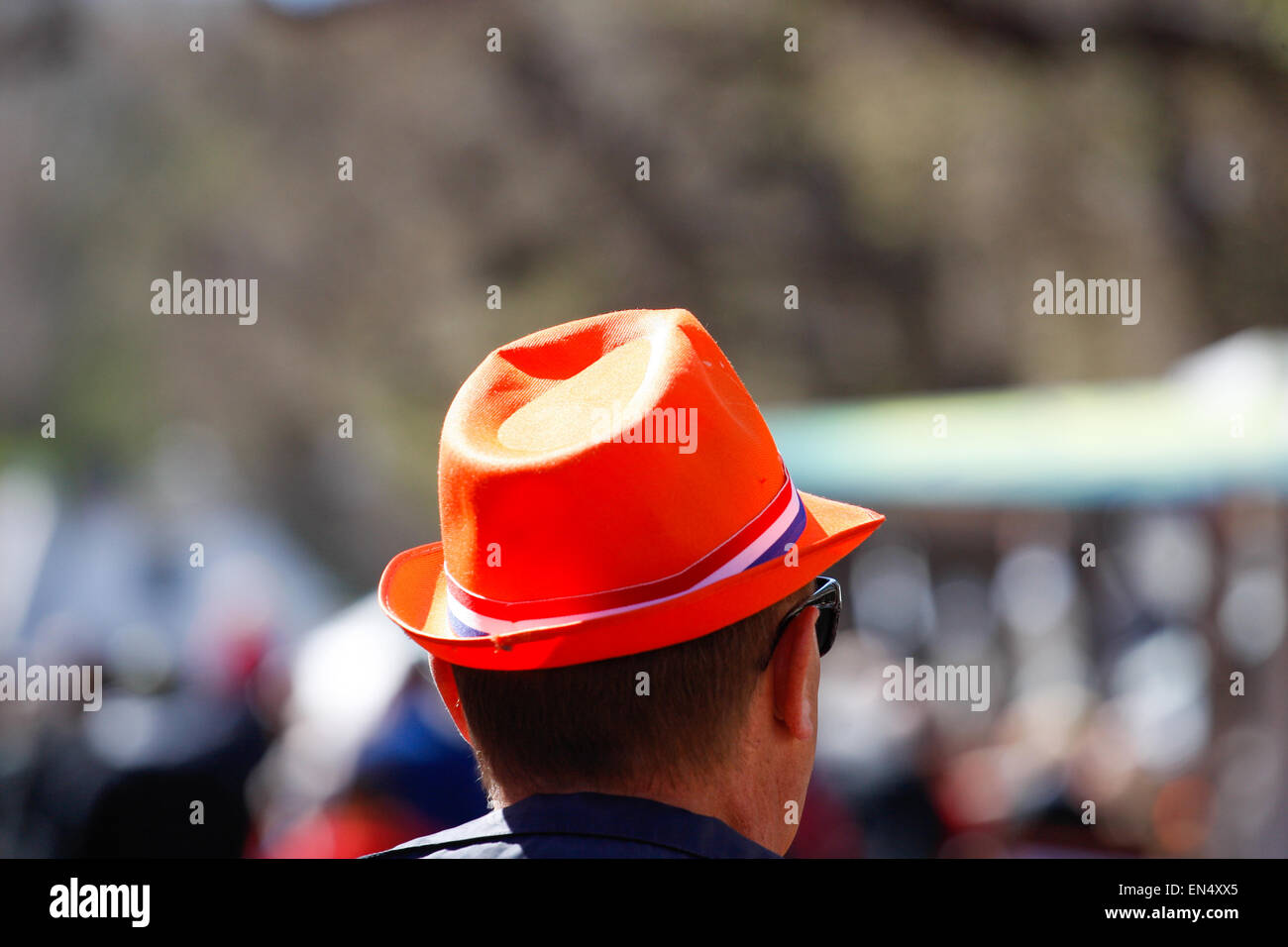 Voorschoten, Netherlands. 27th, April 2015. A man is seen with an orange hat and the Dutch flag. During the annual King’s Day celebrations people decorate themselves with orange colored accessories in honour of the royal family. Credit:  Jaap Arriens/Alamy Live News Stock Photo