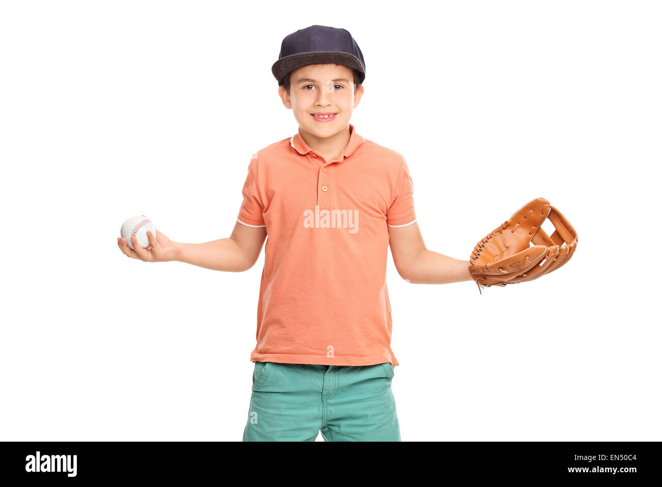 Little boy in an orange shirt and blue cap, wearing a baseball glove and holding a baseball isolated on white background Stock Photo