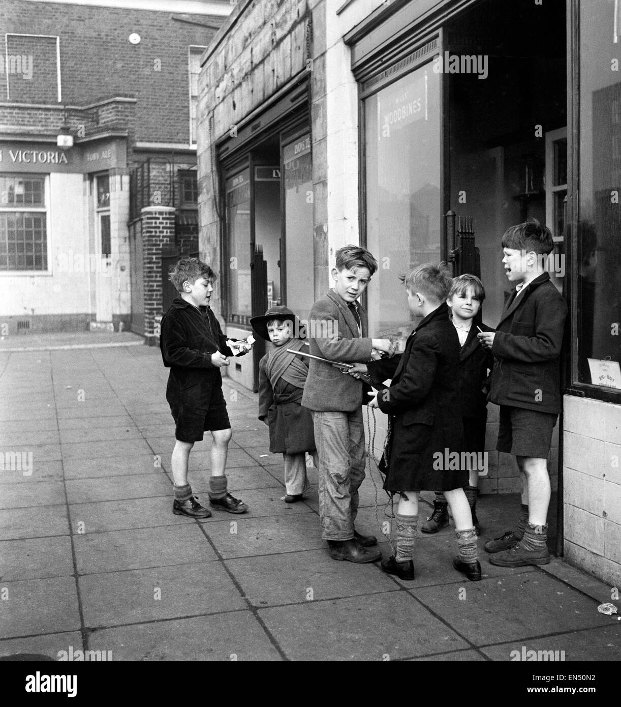 Life in the Mirror Our Gang. 19th January 1954  A gang of boys plot todays agenda of mischief and mayhem outside a tobacconist in Bow Road in the East End of London *** Local Caption *** This is The Conference. Not the stiff necked, prim and tight lipped Stock Photo