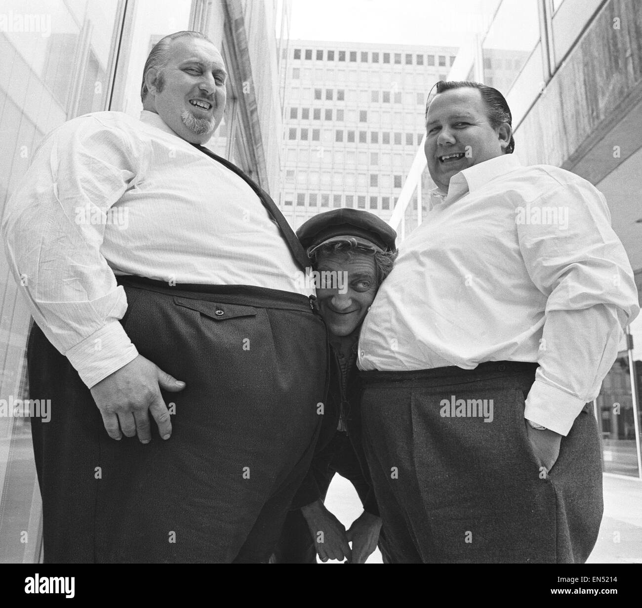 Marty meets the heavy mob. Fifteen of Britains fattest men came to the rescue of a new film starring zany comedian Marty Feldman (centre). James Clark who is dirrecting Marty in 'Every Home Should Have One', was hard pressed to find enough fat men for an Stock Photo