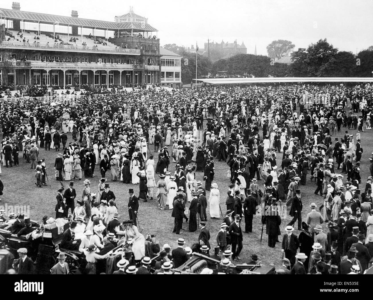 Varsity cricket match at Lords. Oxford v Cambridge. Well dressed spectators on the field in front of the main stand. 9th July 1914. Stock Photo