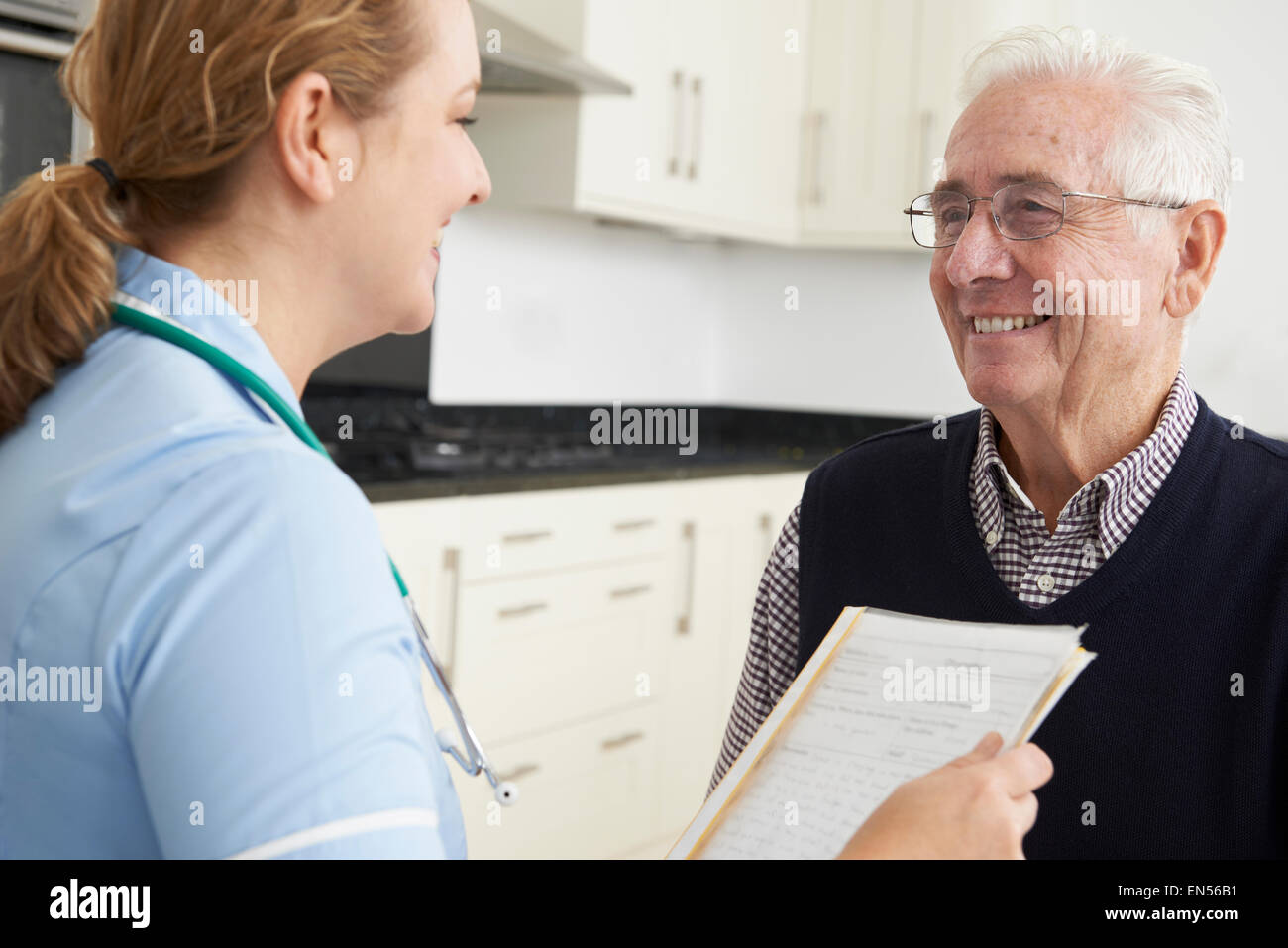 Nurse Discussing Medical Record With Senior Male Patient Stock Photo